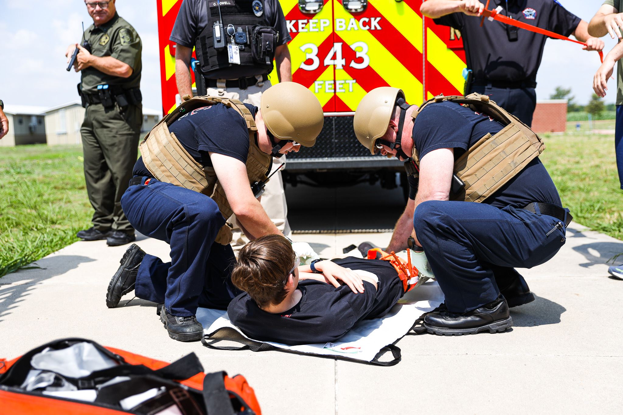 Firefighter using training gear on teenager laying down