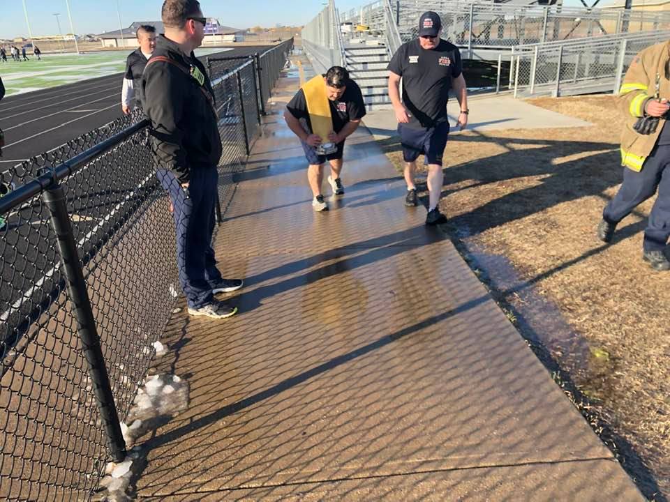Man dragging firehose over his back for firefighter training
